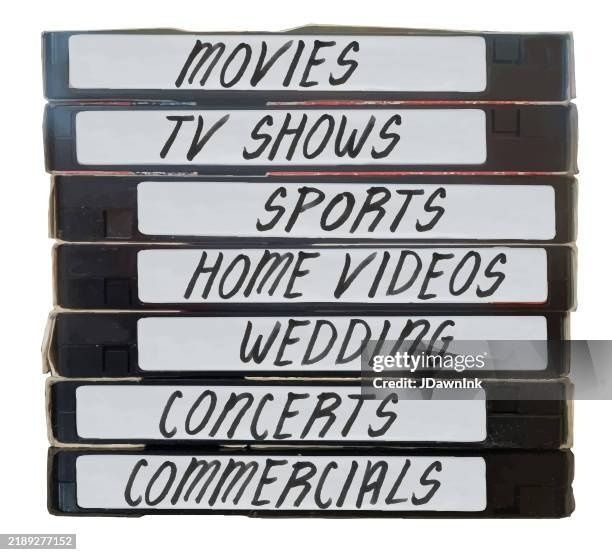 Gestapelte VHS-Kassetten mit handbeschrifteten Kategorien wie „MOVIES